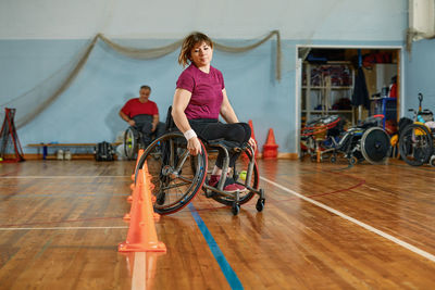 Rear view of young woman sitting on wheelchair