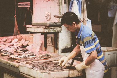 Side view of man selling fish in market