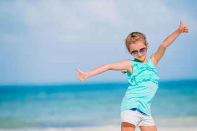 Low angle view of boy wearing sunglasses at beach against sky