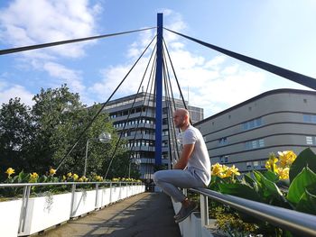 Man in city against sky