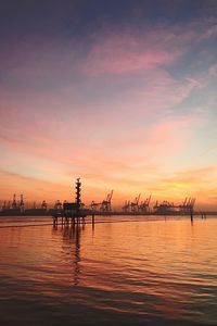 Pier on sea at sunset