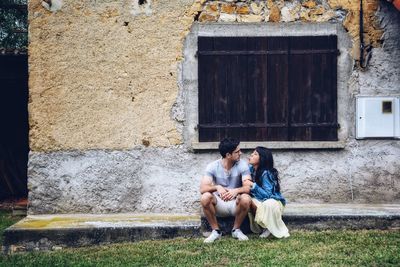 Couple sitting against wall