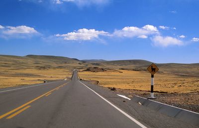 Empty road on desert against sky