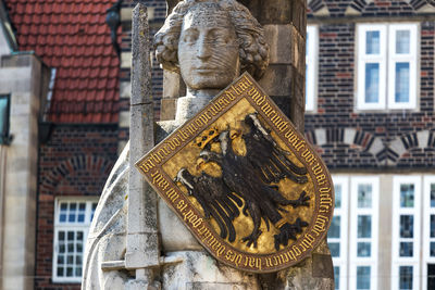 Low angle view of statue against building in city