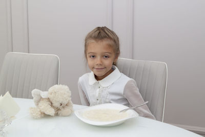 Portrait of cute boy sitting on table