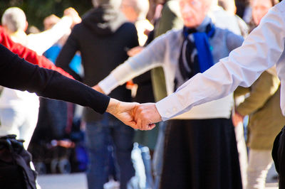 Group of older people dancing at a traditional festival in crowded city 