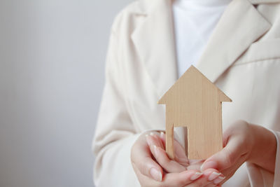 Midsection of woman holding model house on table