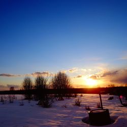 Scenic view of snow field against sky during sunset