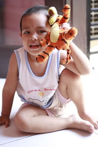 Cute little boy playing with his tiger doll