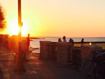 Silhouette of man looking at sea at sunset