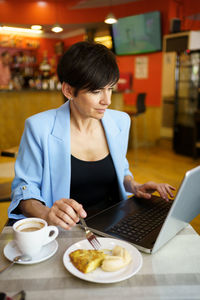 Young woman using laptop at table