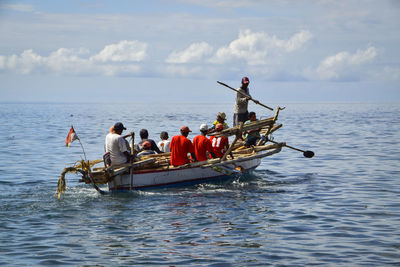 People in boat on sea against sky