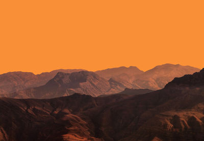 Scenic view of mountains against orange sky