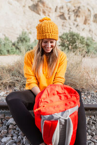 Smiling young woman sitting on railroad track