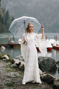 Woman standing with umbrella in rain
