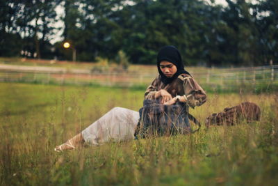 Full length of woman sitting on field