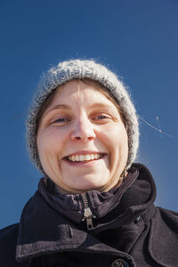 Close-up portrait of smiling woman wearing knit hat during winter