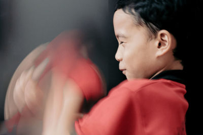 Close-up of boy against black background