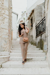 Full length of woman standing on steps outdoors