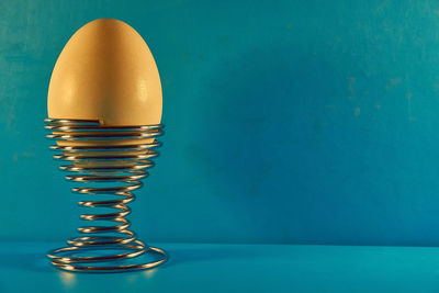 Close-up of spiral on table against blue wall