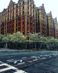 Road by buildings against sky in city