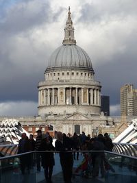 People at town square against cloudy sky