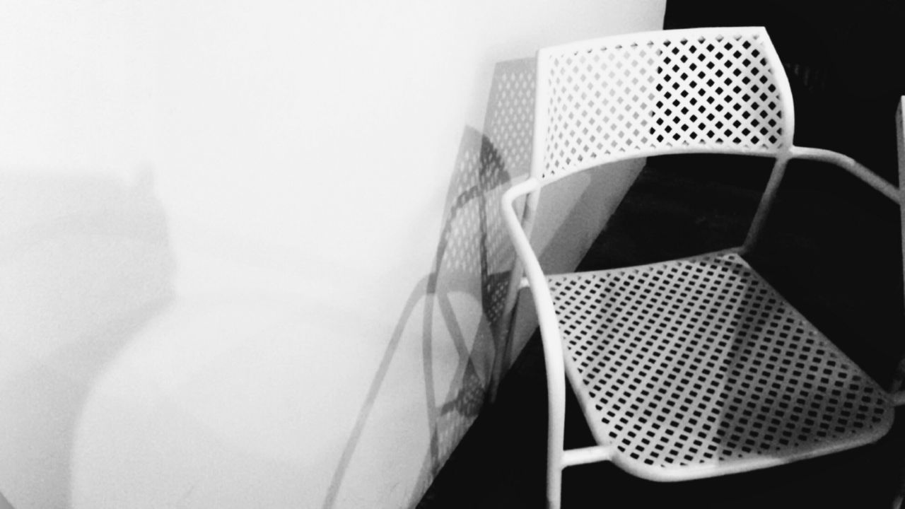 CLOSE-UP OF CHAIRS ON TABLE AGAINST WALL