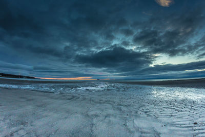 Scenic view of sea against storm clouds