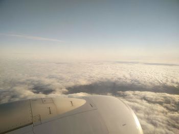 Airplane flying over cloudscape against sky