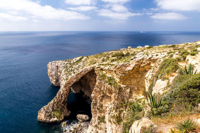 Scenic view of rock formation in sea against sky