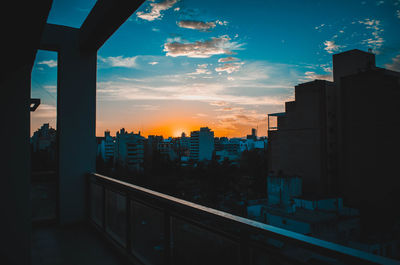 Silhouette buildings against sky during sunset