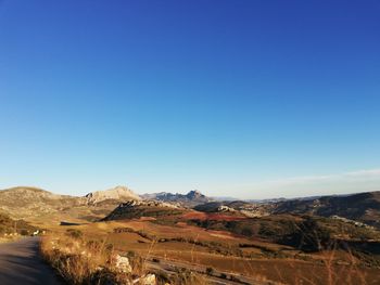 Scenic view of desert against clear blue sky