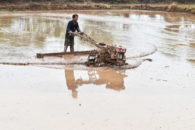 Full length of man working in lake