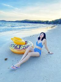 Portrait of woman on beach against sky