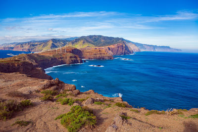 Scenic view of sea and mountains against sky