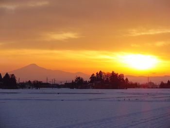 Scenic view of silhouette landscape against orange sky during sunset