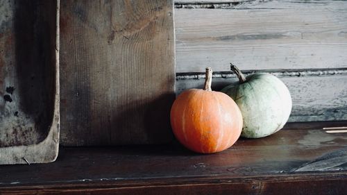 Close-up of pumpkins on table against wall