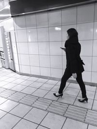 Full length of woman standing on tiled floor