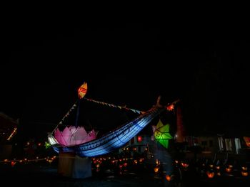 Illuminated flags in city against sky at night
