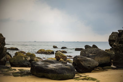 Rocks on beach against sky