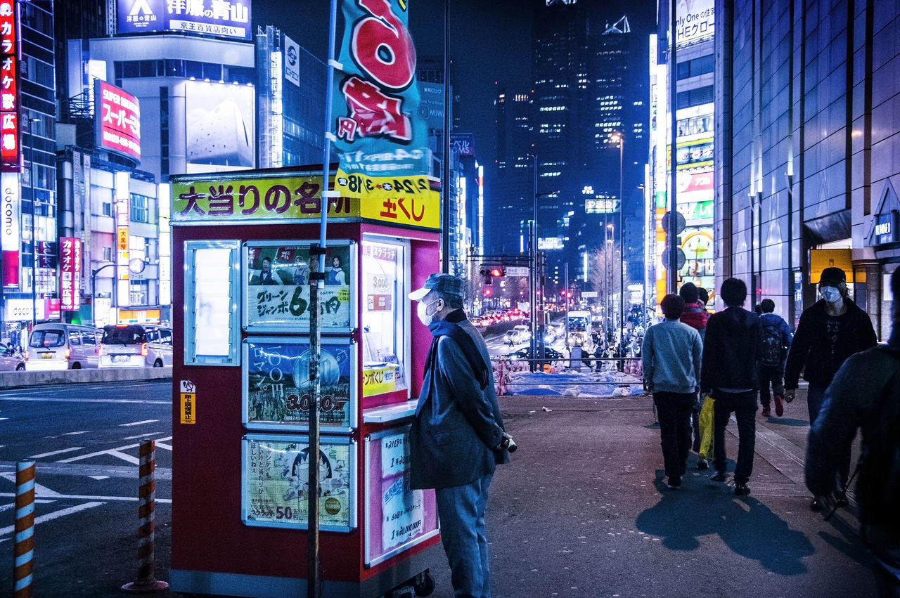 city, building exterior, architecture, street, built structure, city life, lifestyles, city street, illuminated, night, leisure activity, road, casual clothing, building, outdoors