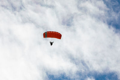 Low angle view of person paragliding against sky