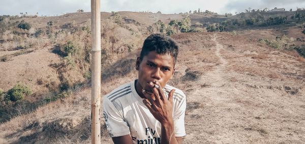 Portrait of young man standing on desert