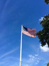 Low angle view of flag against blue sky