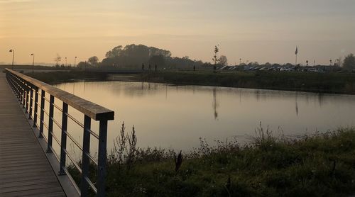 Scenic view of lake against sky at sunset