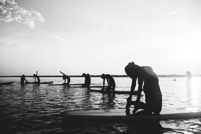 Men working on sea against sky