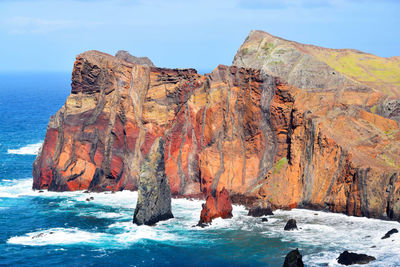 Panoramic view of rocks on sea shore against sky