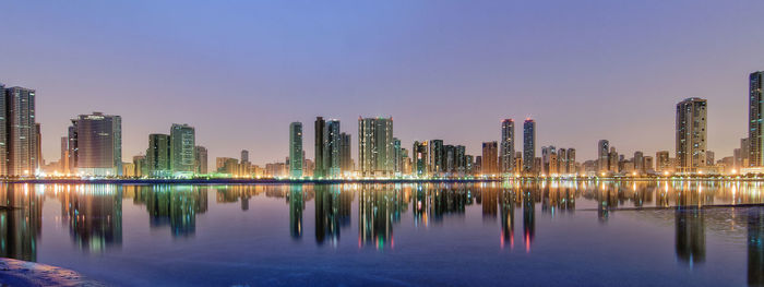 Reflection of city in water against sky