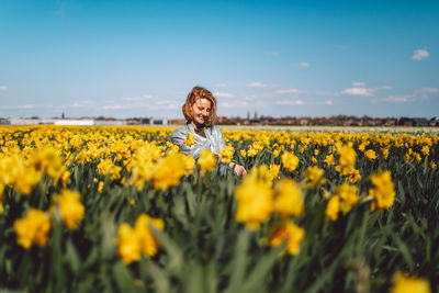 Woman standing on yellow flower field