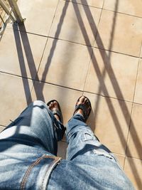 Low section of man standing on tiled floor